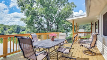 A wooden deck with outdoor furniture, a table, and chairs.