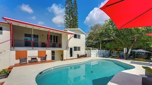 A modern house with a swimming pool, outdoor furniture, and a red awning. - Oakland Park Gem w/ Year-round Pool, 4 Mi to Beach (Fort Lauderdale)