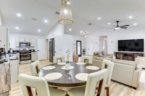 Una cocina moderna con armarios blancos, un microondas y una estufa.