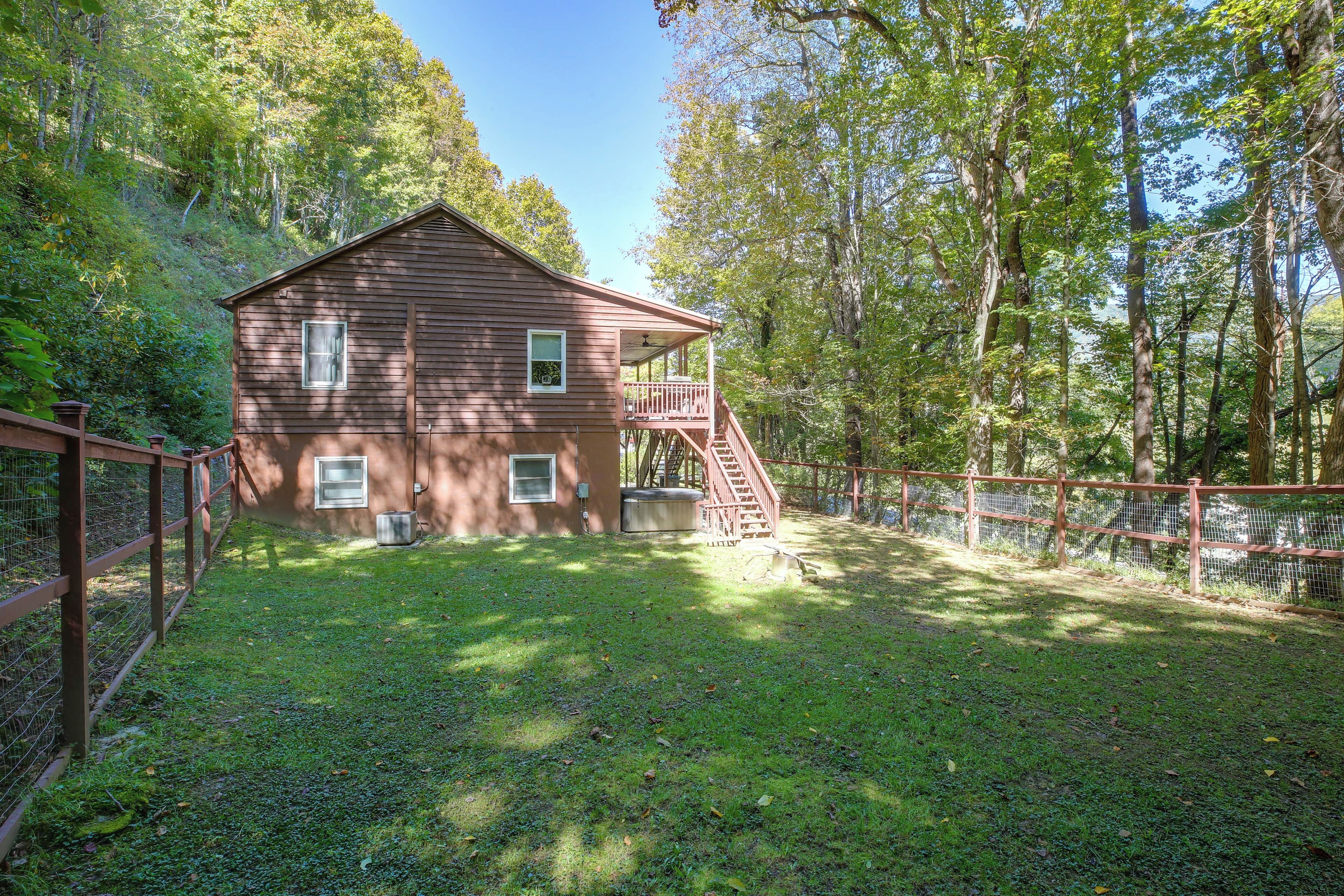 A two-story wooden cabin with a porch and a staircase leading to a deck.