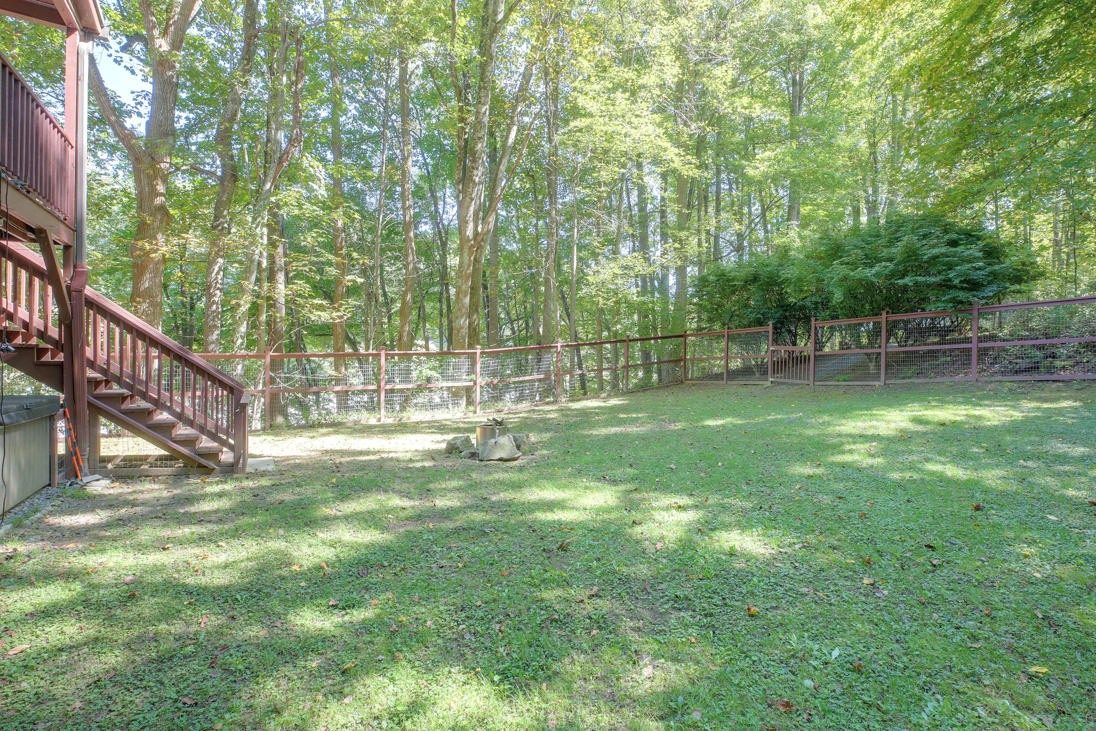 A fenced outdoor area with a wooden deck and stairs leading to a building.