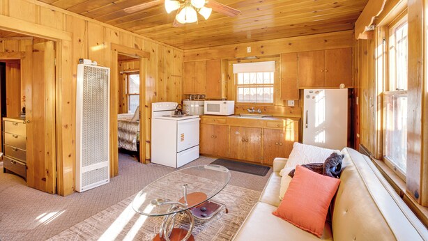 A wooden cabin interior with a kitchen, a dining area, and a living room with a sofa. - Close to Lake & Heavenly Mtn Resort! Quaint Cabin (South Lake Tahoe)