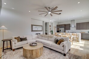 A modern living room with a sectional sofa, a round coffee table, and a ceiling fan. - Sunnyside View: ABQ Home Near Old Town & Biopark! (Albuquerque)