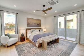 A bedroom with a large bed, a ceiling fan, a view through the window, and a bench. - Sunnyside View: ABQ Home Near Old Town & Biopark! (Albuquerque)