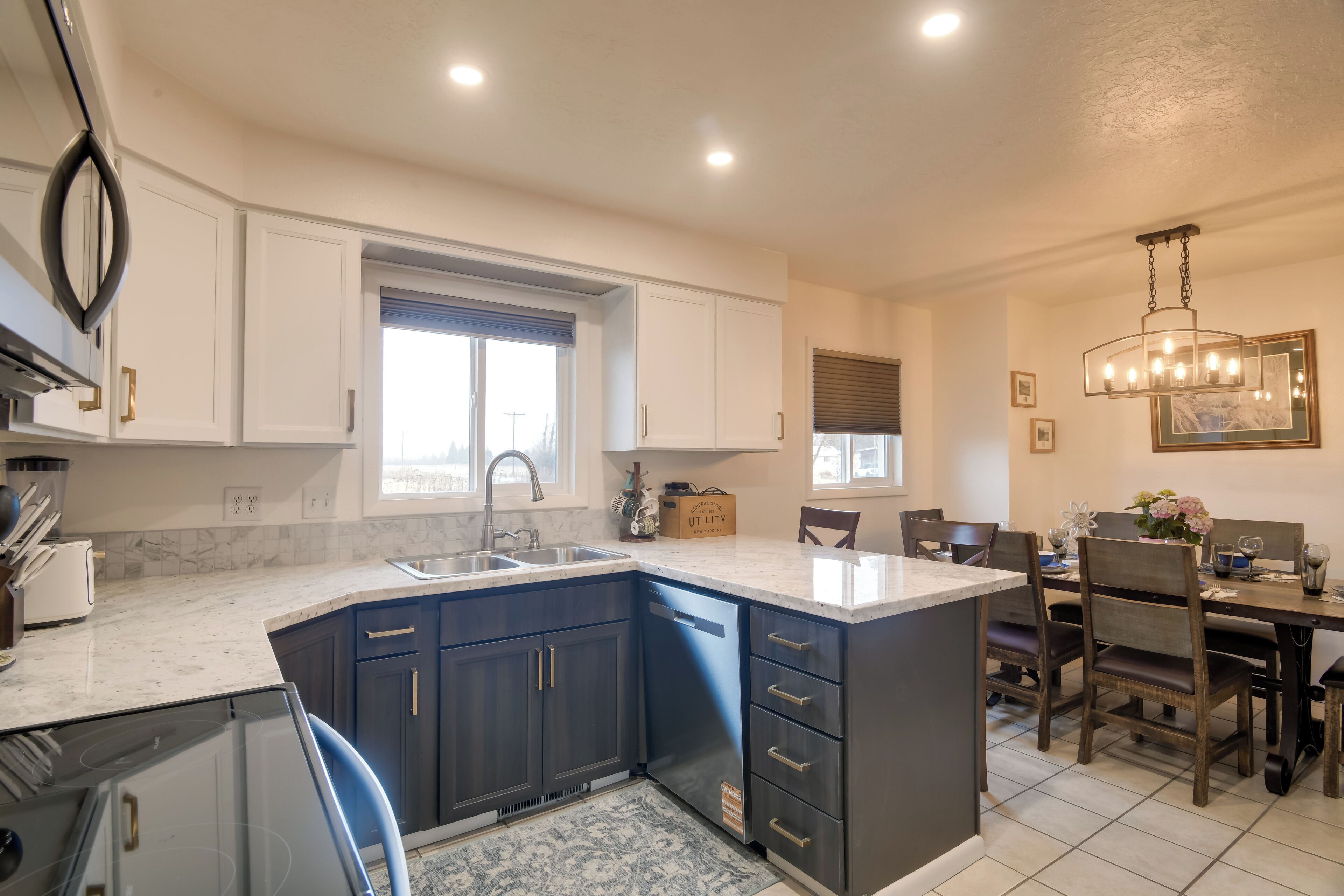 A kitchen with dark blue cabinets, a white countertop, and a built-in island with a sink.