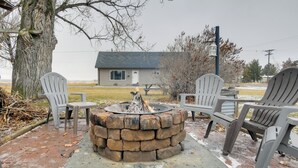 A fire pit surrounded by Adirondack chairs, a brick fire pit, and a house in the background. - 5 Mi to Heise Hot Springs: 'the Trout House' (Ririe)