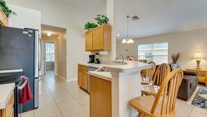 A modern kitchen with a central island, wooden cabinets, and a built-in oven. - Poolside Oasis & Game Room Fun! Gem in Haines City (Haines City)