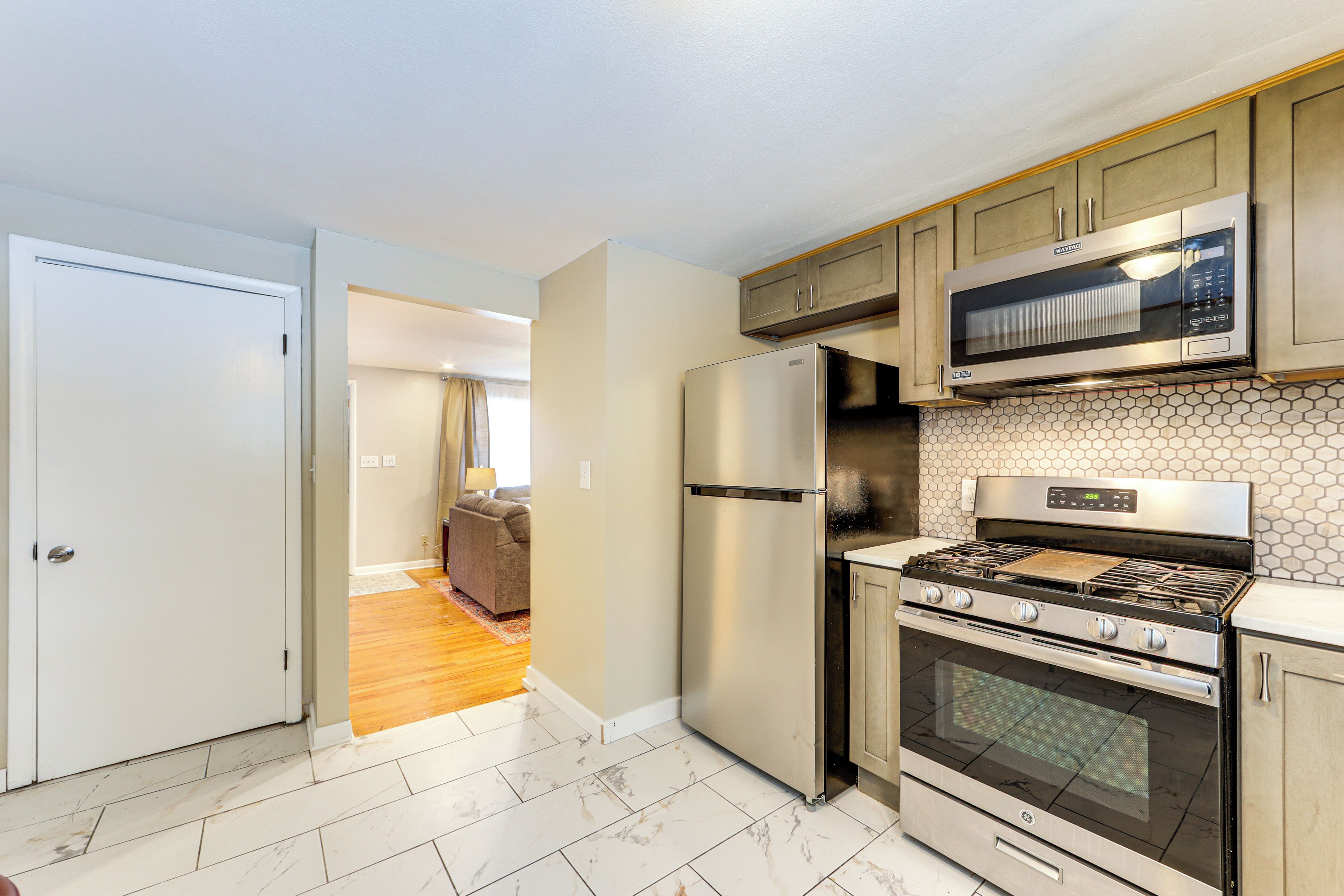 A modern kitchen with stainless steel appliances, a microwave, a refrigerator, and a stove.