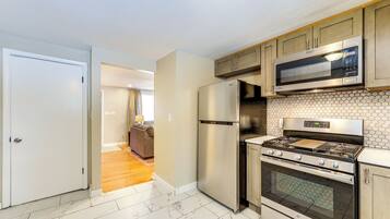 A modern kitchen with stainless steel appliances, a microwave, a refrigerator, and a stove.