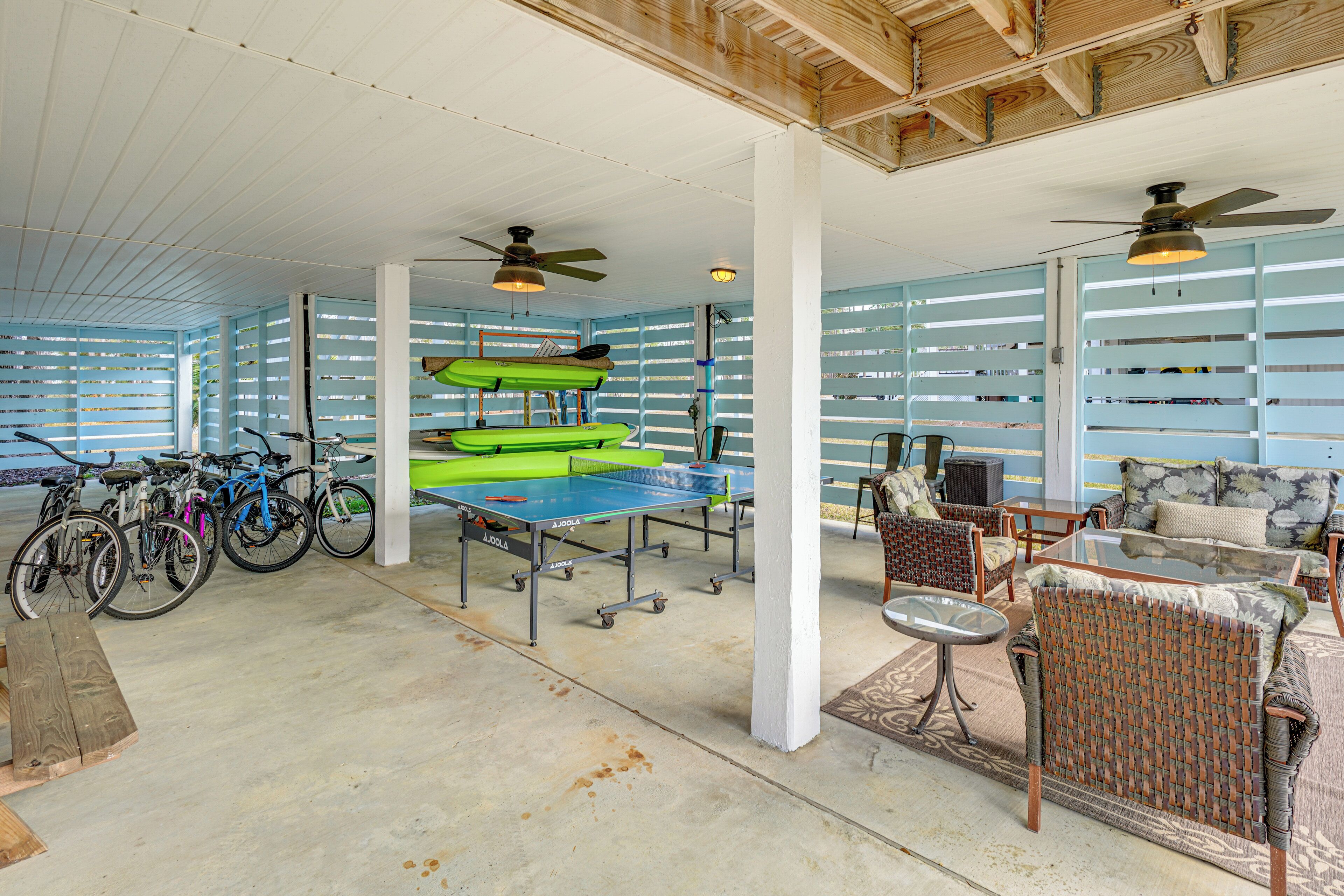 A spacious indoor area with ceiling fans, a ping pong table, and bicycles.