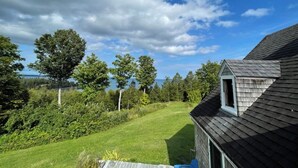 A house with a sloped roof and a small attic window. - Private Beach! Passamaquoddy Bay Cottage (Perry)