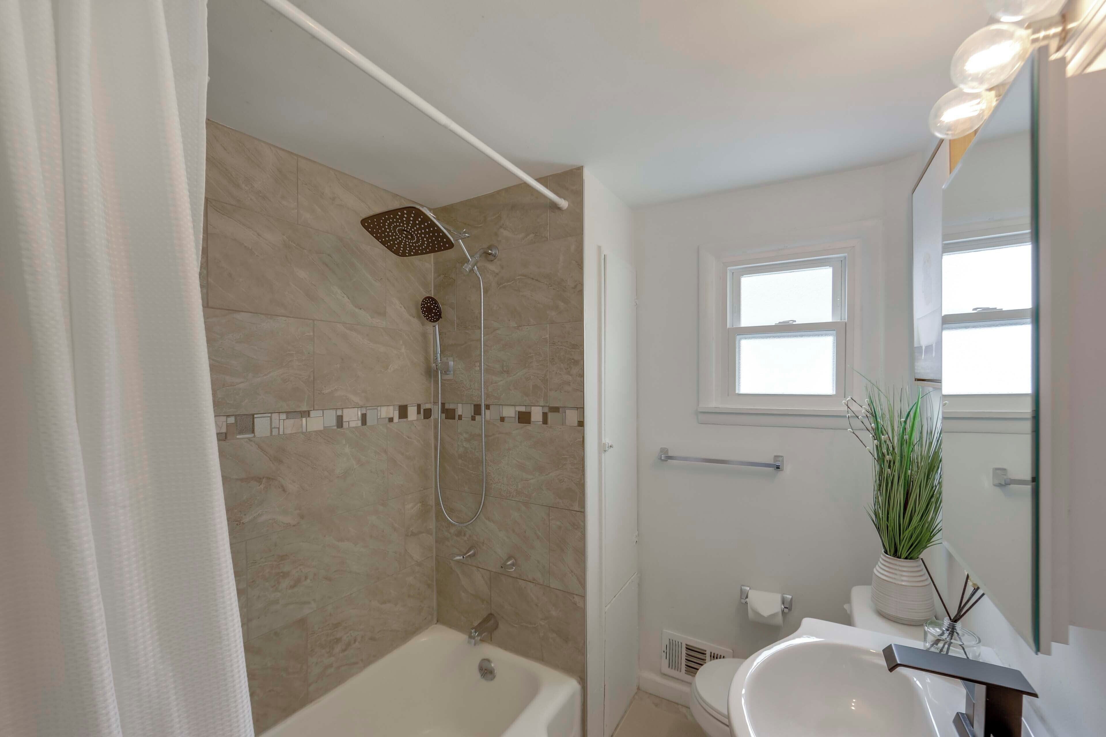 A bathroom with a shower, bathtub, and sink.