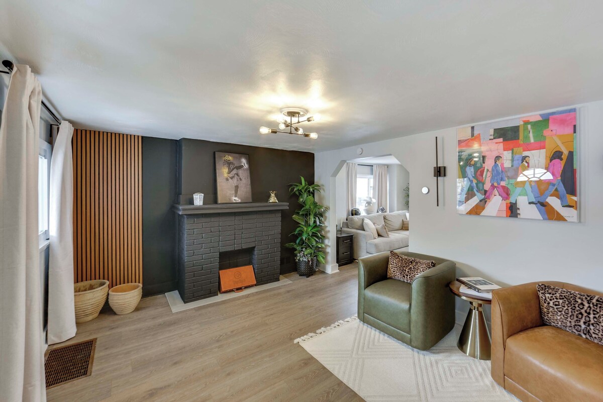 Un salon moderne avec une cheminée, un canapé, une table basse et un tableau au mur.