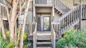 A wooden building with a staircase leading to a door. - Golfer's Getaway! Modern Diamondhead Condo (Diamondhead)
