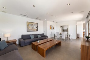 Ein modernes Wohnzimmer mit Sofa, Couchtisch und Essbereich.
