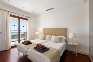 Ein Hotelzimmer mit zwei Betten, einem Balkon und Blick auf die Stadt.