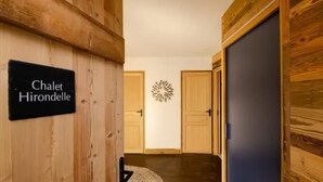 Een houten gang met een bord waarop 'Chalet Hirondelle' staat.
