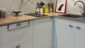 Una cucina moderna con zoccolo in marmo, soffitto in legno e lavello dotato di un rubinetto elegante.
