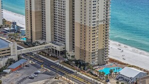 A high-rise hotel with multiple floors, a parking lot, and a beach view. - TW 1600-King Bed-Arcade-Sauna-New Listing (Panama City Beach)