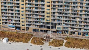 A high-rise hotel with multiple balconies and a beach area in the foreground. - TW 1600-King Bed-Arcade-Sauna-New Listing (Panama City Beach)