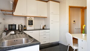 A modern kitchen with a sink, microwave, and a chalkboard menu.