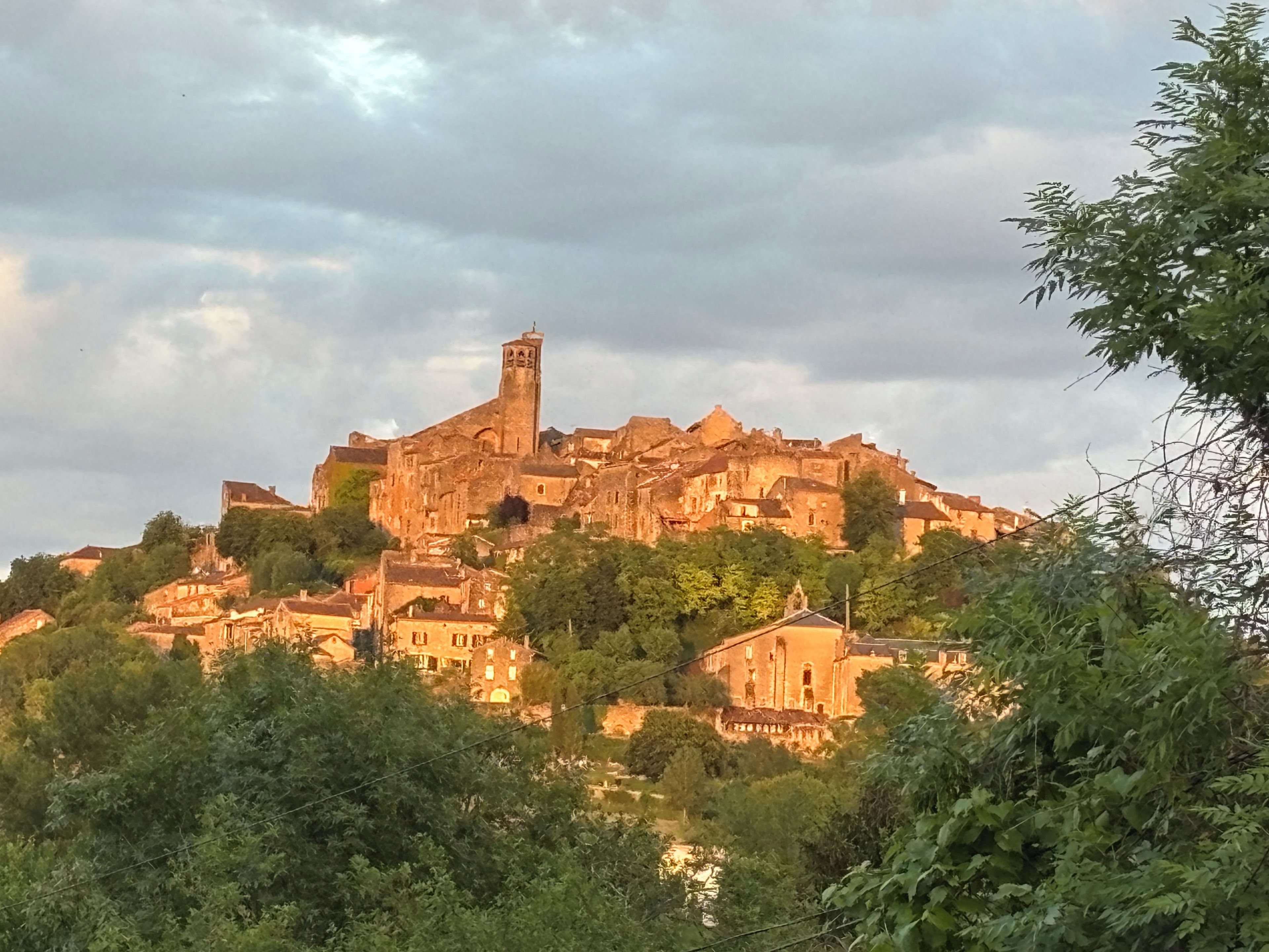 A historic hilltop town with a prominent church featuring a tall bell tower.