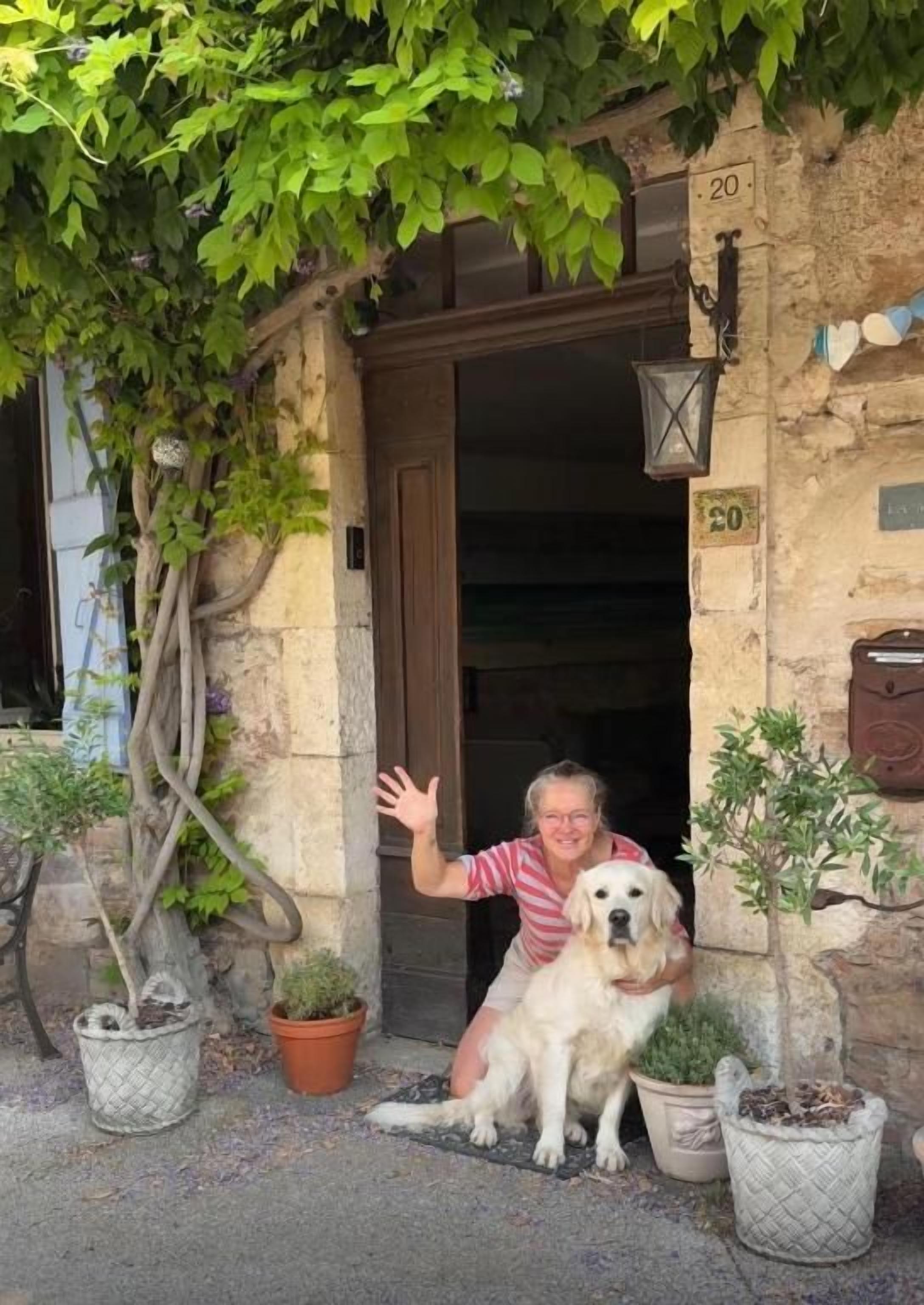 A stone building entrance with a dog and a person.