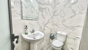 Een douche, handdoeken, zeep, toiletpapier