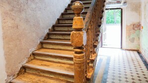 A staircase with wooden steps and a balustrade, leading to an open doorway.