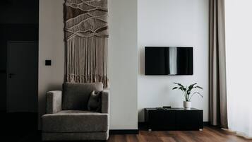 Comfort Apartment | Living room | 32-inch TV with satellite channels, books