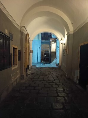 Ein enger, steinerner Gang mit Gewölbedecke, der zu einer Treppe führt.