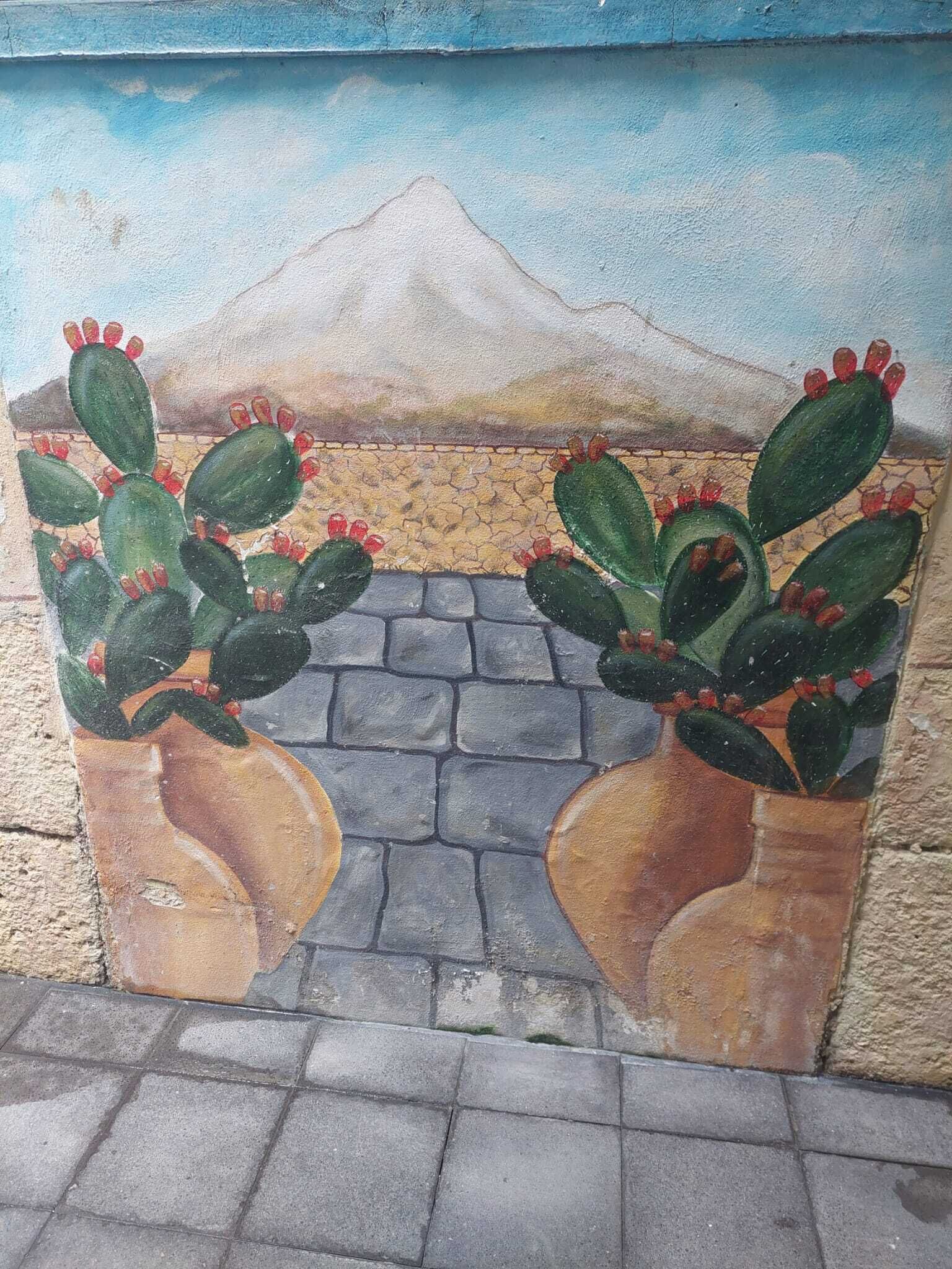 A mural with cacti and a mountain.