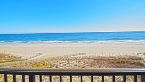 A beach with a clear view of the ocean and a fenced area in the foreground. - Sandpiper Dunes 605 2 Bedroom Condo (Ocean City)