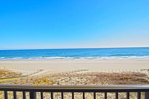 A beach with a clear view of the ocean and a fenced area in the foreground. - Sandpiper Dunes 605 2 Bedroom Condo (Ocean City)