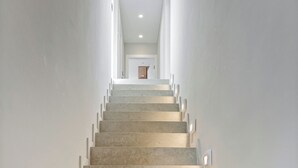 Un escalier au design moderne, composé d’une série de marches et doté d’un éclairage mural.