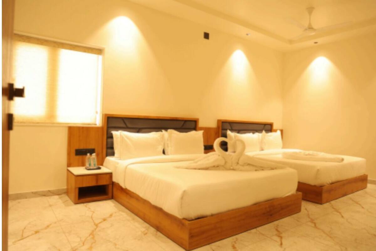 A hotel room with two beds, a wooden headboard, a nightstand, and a marble floor.