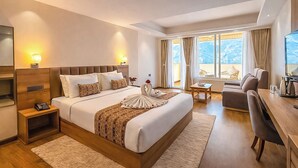 Una camera d'albergo con un letto grande, comodini, una scrivania e vista sull'esterno.