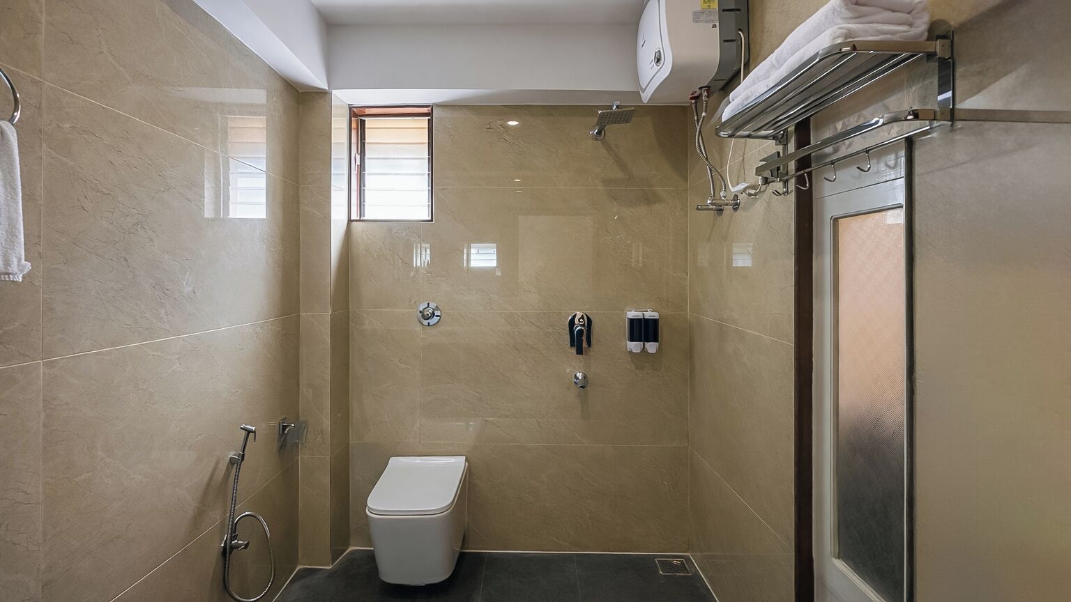 A modern bathroom with a toilet, a shower, and a towel rack.