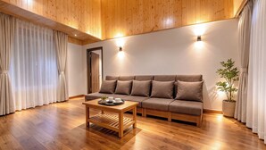 Un soggiorno moderno con soffitto in legno, un divano, un tavolino da caffè e una pianta in vaso.