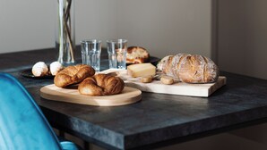 A dining table with pastries, a vase of flowers, and glasses. - Avenue Chalet (Špindlerův Mlýn)