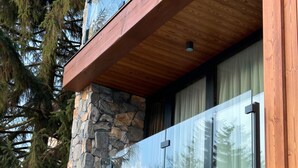 A modern building with a stone facade, large windows, and wooden beams. - Avenue Chalet (Špindlerův Mlýn)