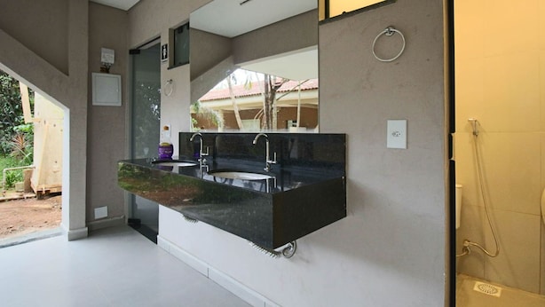 Un baño moderno con un espejo grande, dos lavamanos y una zona de ducha.