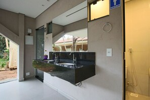 A modern bathroom with a large mirror, two sinks, and a shower area. - Casa com Piscina e Churrasqueira em Taguatinga (SCIA)