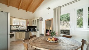 Una cocina con una mesa redonda de madera, una lavadora y un lavaplatos.