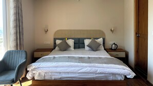Een slaapkamer met een bed, twee nachtkastjes, een stoel, een houten deur en een raam met gordijnen.