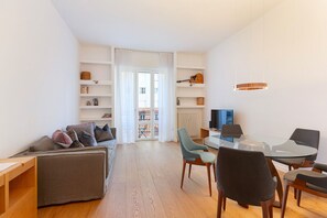 A modern living room with a sofa, chairs, a glass table, and a TV. - easyhomes - Piazza Erculea (Milan)