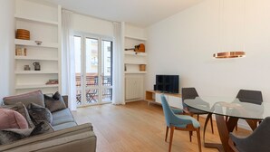 A modern living room with a glass dining table, a sofa, and a TV. - easyhomes - Piazza Erculea (Milan)