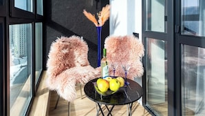 A modern room with large windows, a black-framed table with fruits and a bottle, and a fluffy chair. - Apartments near Aerodromnaya metro st (Minsk)