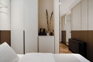Ein modernes Hotelzimmer mit einem Bett, Nachttischen, einem Heizkörper und einem Spiegel.