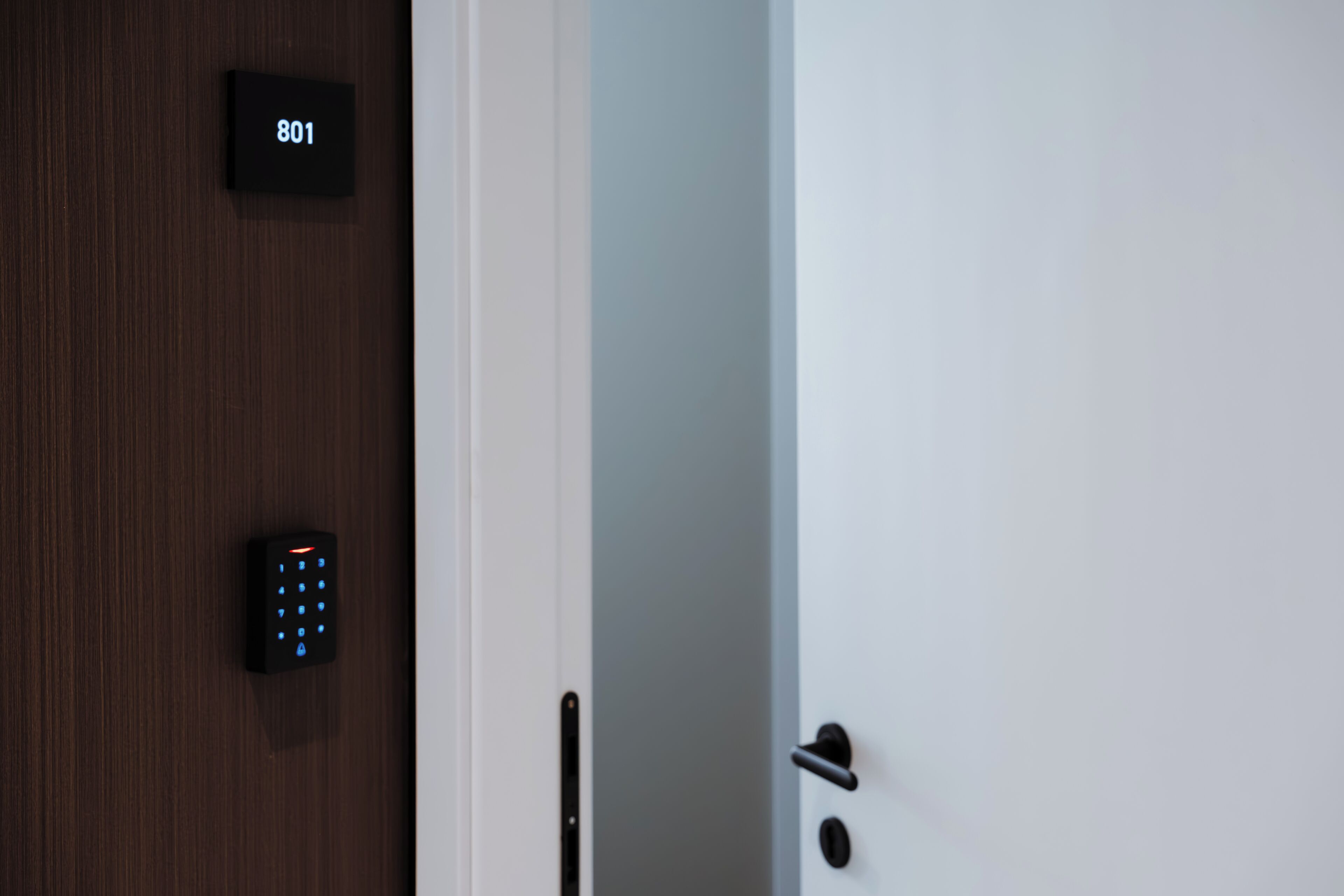 Una puerta con teclado numérico y letrero de número de habitación.